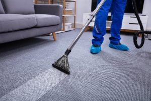 Low,Section,Of,A,Male,Janitor,Cleaning,Carpet,With,Vacuum
