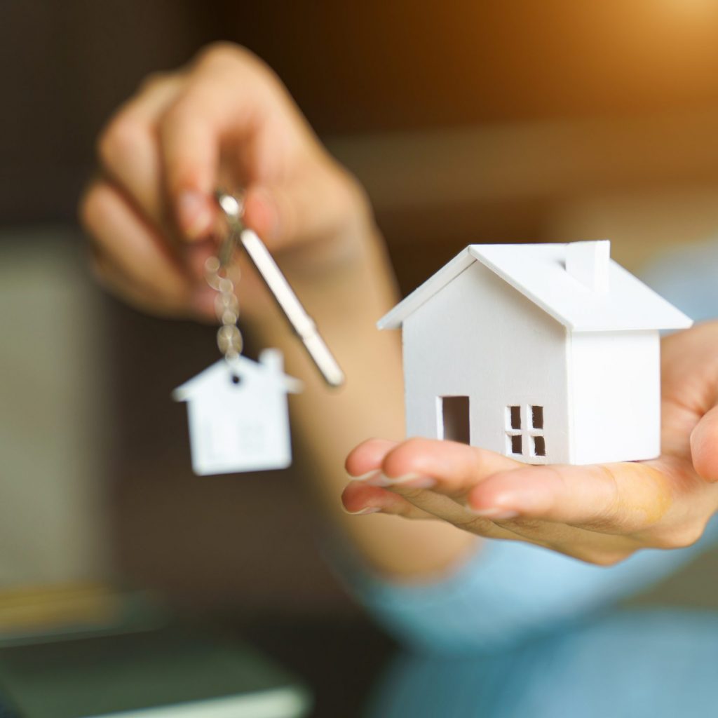 Woman,Holding,White,House,Model,And,House,Key,In,Hand.mortgage